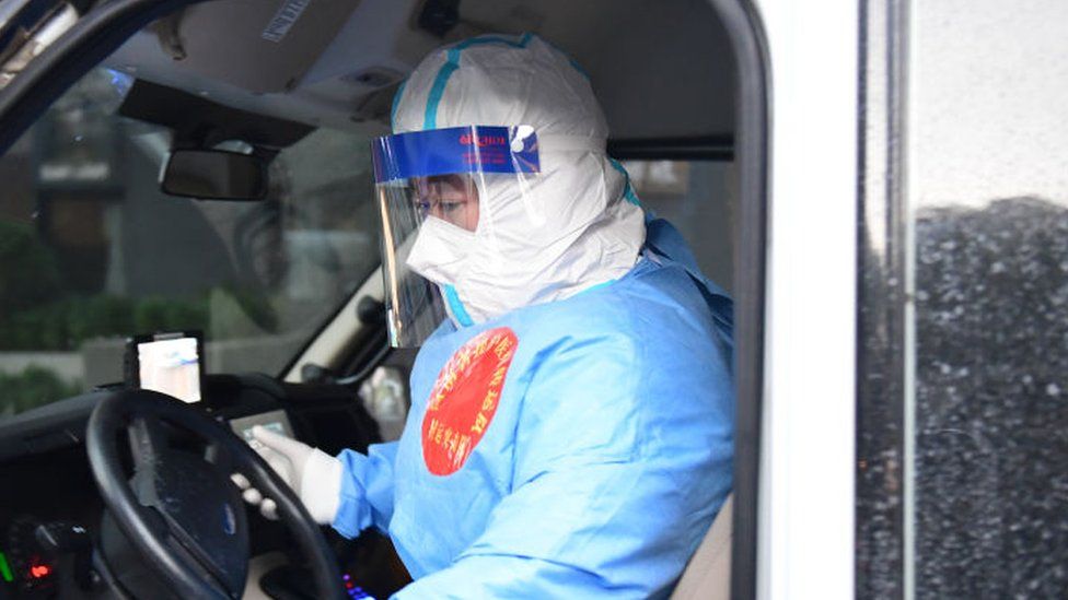 Un miembro de un equipo de asistencia médica se sube a una ambulancia para llevar a los pacientes de Covid-19 a un hospital en Shanghái, China.