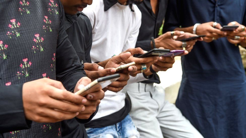 Hombres indios usando sus teléfonos