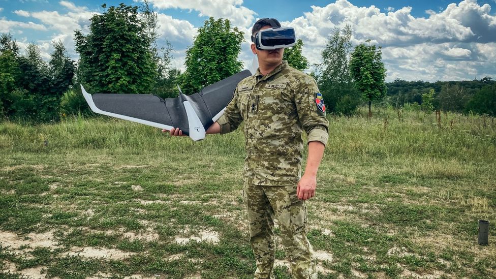 Un soldado ucraniano con gafas de realidad virtual se prepara para lanzar un dron 