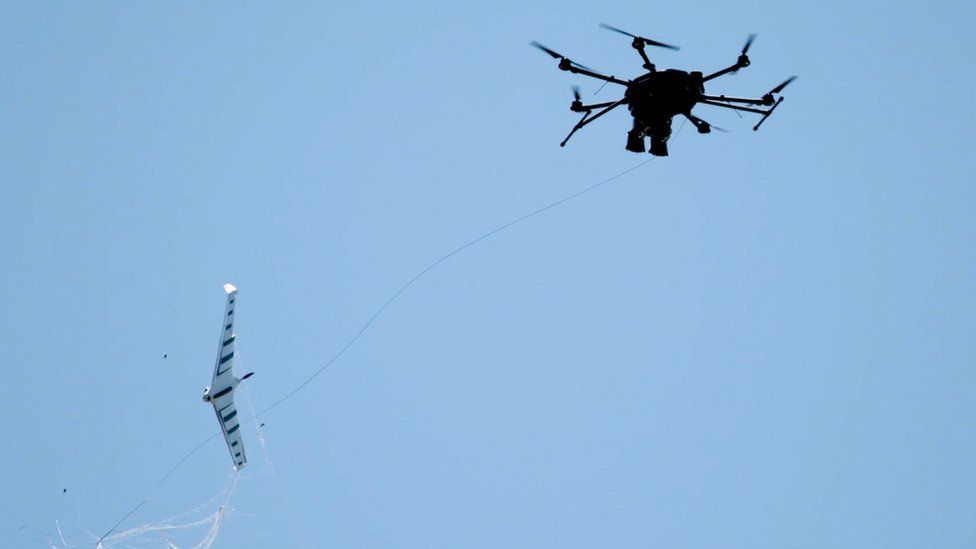 Un dron capturando un dron de ala fija